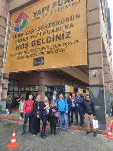 grupa ludzi pozujących do zdjęcia przed budynkiem